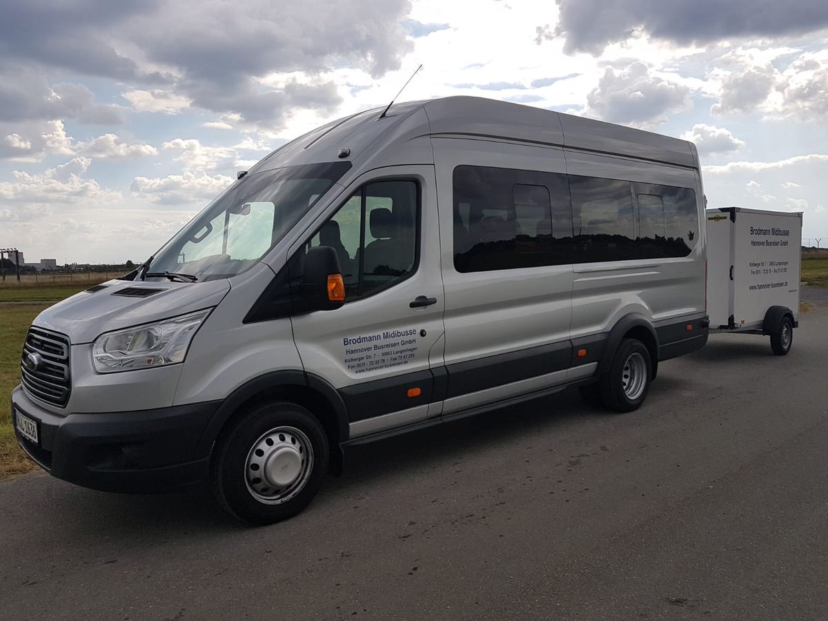 Ford Transit Midibus mit angehängtem Gepäckanhänger